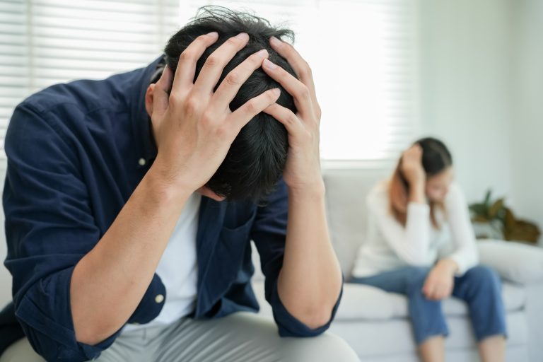 a couple holding their heads in their hands